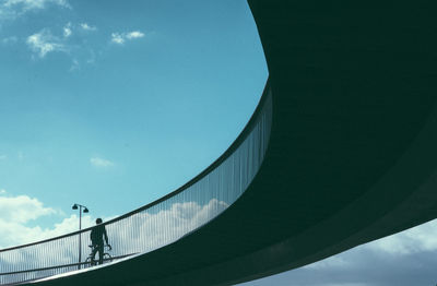 Low angle view of man on bridge against sky