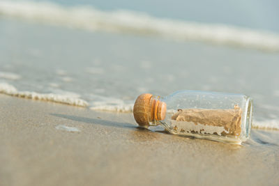 Close-up of bottle on sand at beach