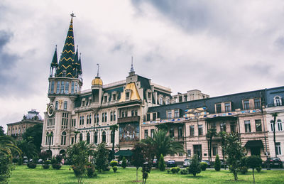 Low angle view of buildings against cloudy sky