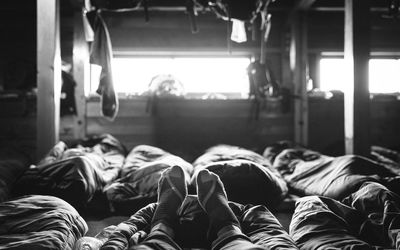 Low section of man sleeping on bed