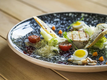 Close-up of caesar salad served in plate on table