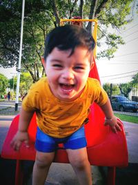 Happy boy playing on swing at playground