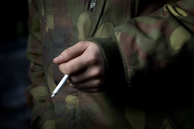 Close-up of hand holding cigarette