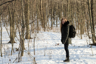 Young woman standing on field during winter