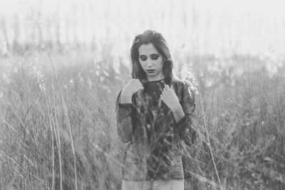 Thoughtful young woman standing on field