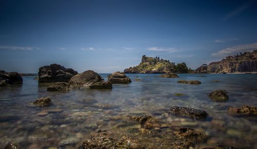 Scenic view of rocks in sea against sky