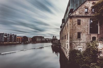 Buildings in city against cloudy sky