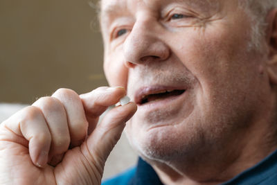 Close-up of senior man talking medical pill