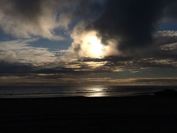 Scenic view of sea against cloudy sky during sunset