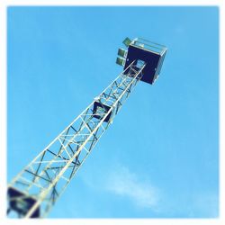 Low angle view of crane against clear blue sky