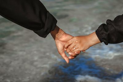 Low section of couple holding hands