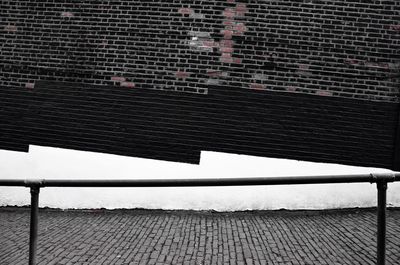 Text on railing against brick wall