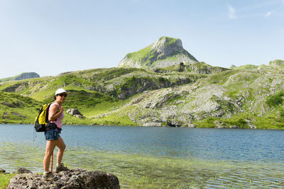 Full length of woman standing at lake against mountain 