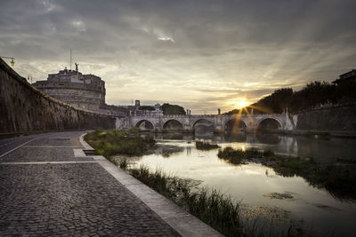 View of bridge over river against cloudy sky