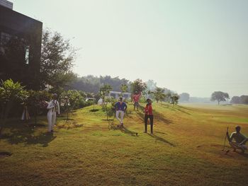 People on field against clear sky