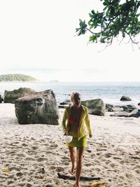 Full length of man standing on beach against sky
