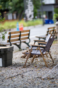 Empty chairs and table on street in city