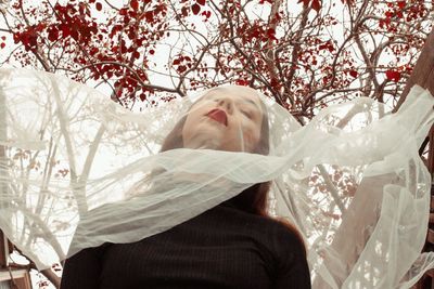 Beautiful woman with scarf against tree