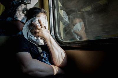 Midsection of man sitting in train