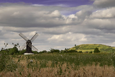 Traditional windmill on field against sky