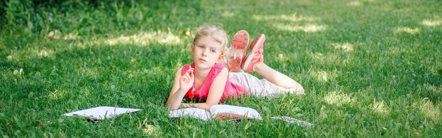 Full length of girl lying down on field