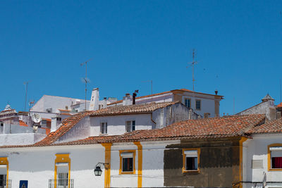 Buildings in city against clear blue sky