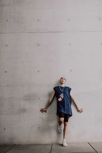 Portrait of young man standing against wall