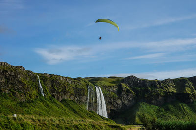 Low angle view of person paragliding against sky