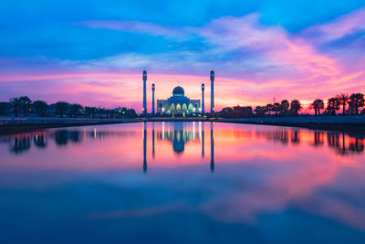 Reflection of building on lake during sunset