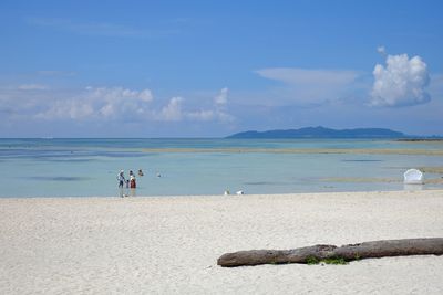 Family standing in sea at beach