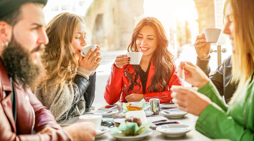 Friends having coffee at table in cafe