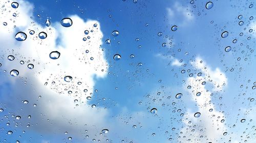 Full frame shot of wet glass against blue background