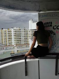 Rear view of woman standing against wall