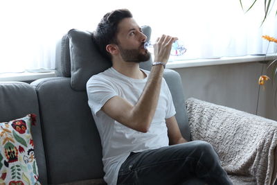 Young man sitting on sofa at home