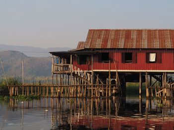 Building by lake against sky