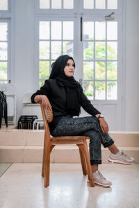 Young woman sitting on sofa at home