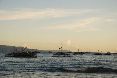 Sailboat sailing on sea against sky during sunset