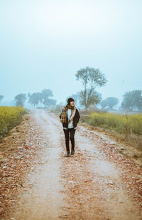 Woman standing on road against sky