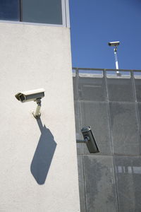 Arrow symbol on metal structure against building on sunny day