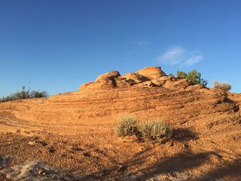 Rock formations in desert against blue sky