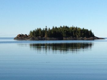 Scenic view of lake against clear blue sky