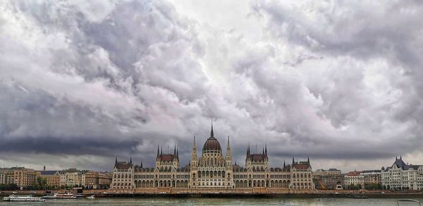 Buildings in city against cloudy sky