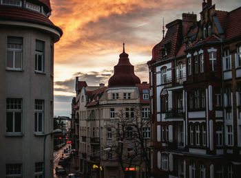 Buildings against cloudy sky during sunset in city