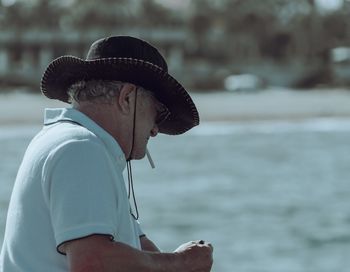 Side view of man looking away while standing outdoors