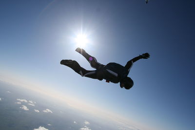 Low angle view of man jumping against clear sky