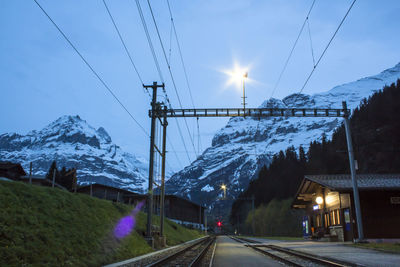 Road by snowcapped mountain against sky during winter