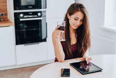 Young woman using mobile phone at home