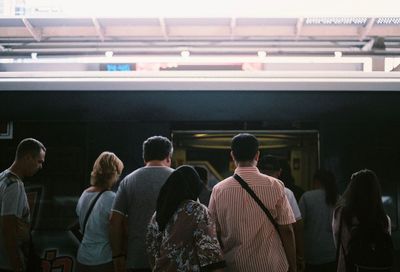 Rear view of people looking at train