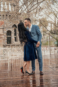 Rear view of couple standing with umbrella