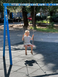 Portrait of boy swinging at playground